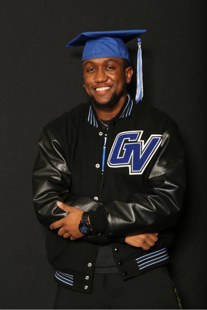 man smiling in grad cap and gvsu jacket